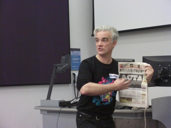 Loz holds up a Polish Newspaper